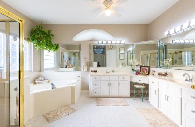423 Hana Dr, Tiki Island, TX 77554 - full bathroom featuring double vanity, ceiling fan, a bath, a stall shower, and tile patterned floors