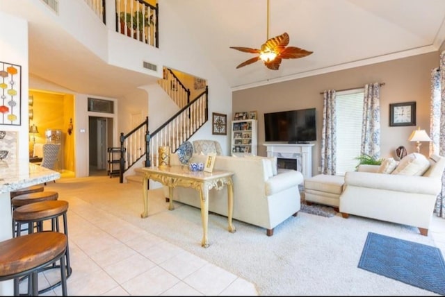 423 Hana Dr, Tiki Island, TX 77554 - carpeted living area featuring stairway, ceiling fan, tile patterned floors, high vaulted ceiling, and crown molding