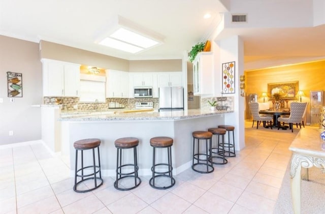 423 Hana Dr, Tiki Island, TX 77554 - kitchen with appliances with stainless steel finishes, backsplash, white cabinets, and crown molding