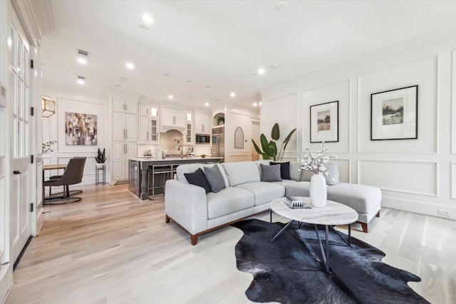432 Marshall St, Houston, TX 77006 - living area with a decorative wall, light wood-style flooring, recessed lighting, and ornamental molding