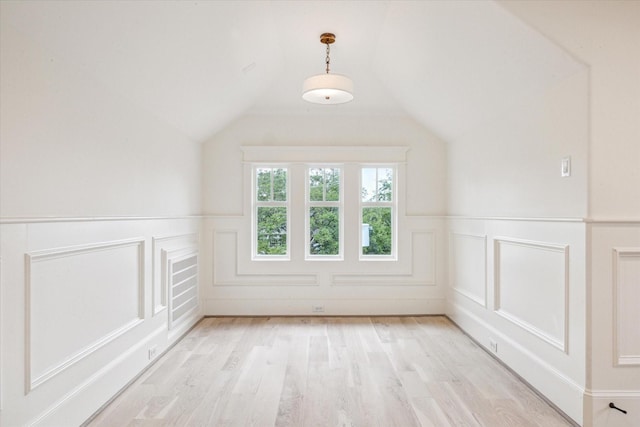 432 Marshall St, Houston, TX 77006 - additional living space with a decorative wall, a wainscoted wall, light wood-style flooring, and vaulted ceiling