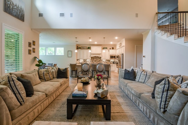 9411 Plaza Point Dr, Missouri City, TX 77459 - living room featuring a high ceiling, stairs, light wood-style floors, and recessed lighting