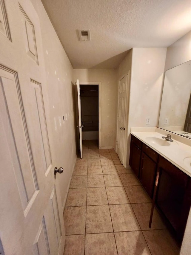 1015 Amaryllis Rd, Baytown, TX 77521 - full bathroom with double vanity, tile patterned flooring, and a textured ceiling