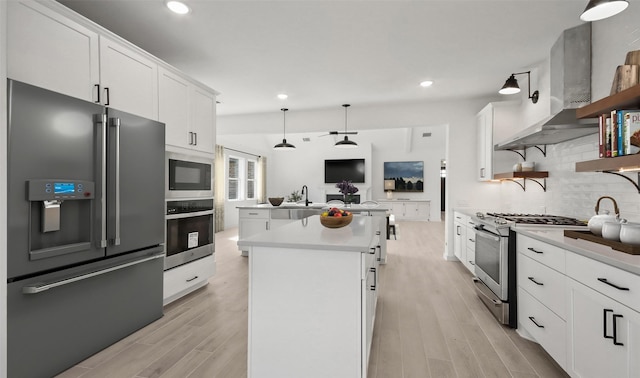 6220 Pelican Ridge Way, League City, TX 77573 - kitchen featuring stainless steel appliances, open shelves, wall chimney exhaust hood, a kitchen island with sink, and tasteful backsplash