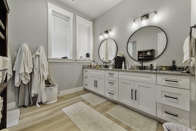 19885 Keenan Cut Off Rd, Montgomery, TX 77316 - bathroom featuring double vanity, wood finished floors, and baseboards