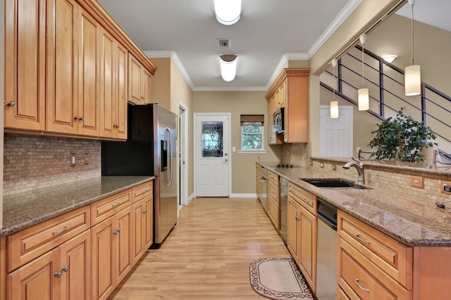 81 Baron Dr, Coldspring, TX 77331 - kitchen with a sink, appliances with stainless steel finishes, tasteful backsplash, light wood-type flooring, and a peninsula