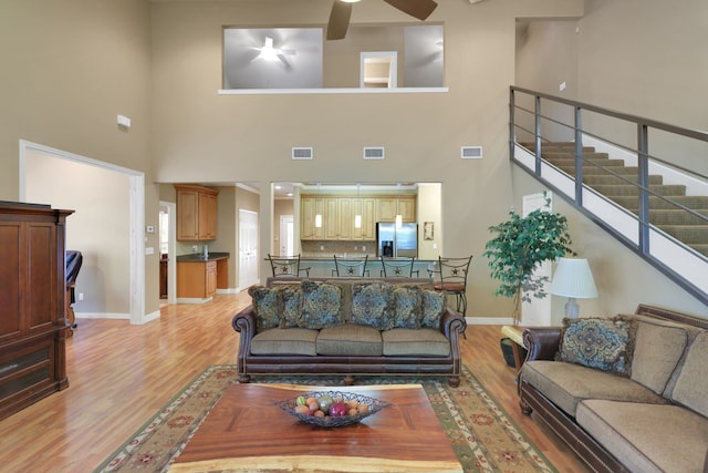 81 Baron Dr, Coldspring, TX 77331 - living room featuring a towering ceiling, light wood finished floors, a ceiling fan, and baseboards