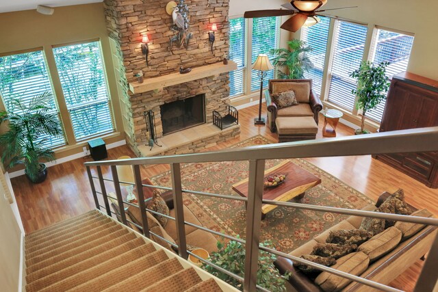 81 Baron Dr, Coldspring, TX 77331 - living area featuring ceiling fan, wood finished floors, a stone fireplace, baseboards, and stairway