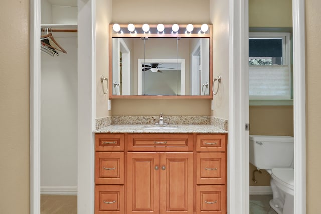 81 Baron Dr, Coldspring, TX 77331 - bathroom featuring vanity, toilet, ceiling fan, baseboards, and tile patterned flooring