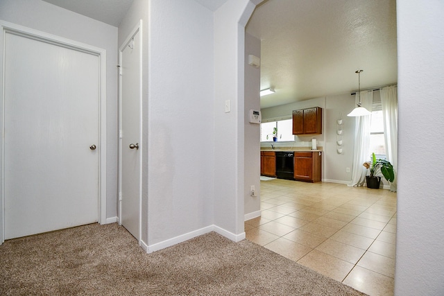2739 Mustang Hill Ln, Katy, TX 77449 - hallway with light tile patterned floors, baseboards, arched walkways, and light carpet