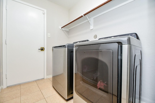 2739 Mustang Hill Ln, Katy, TX 77449 - laundry area featuring washer and clothes dryer, light tile patterned floors, and baseboards