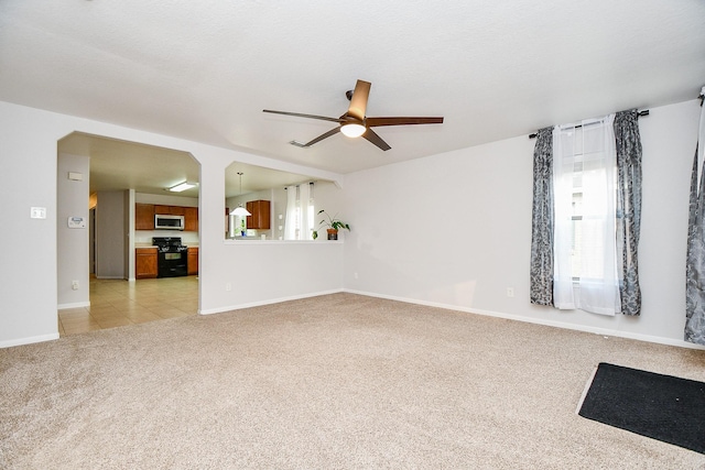 2739 Mustang Hill Ln, Katy, TX 77449 - unfurnished living room with light colored carpet, ceiling fan, and baseboards
