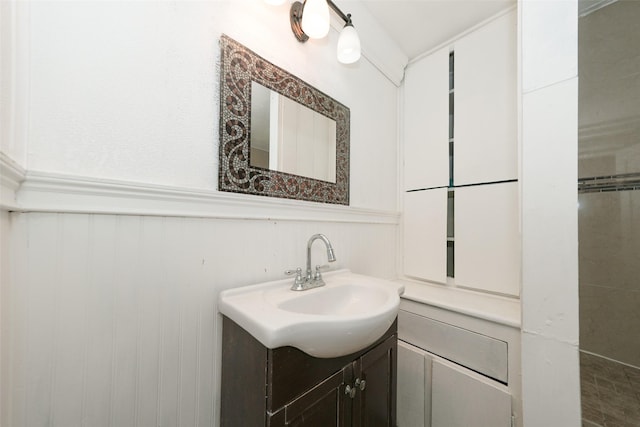 7013 Kittridge St, Houston, TX 77028 - bathroom with vanity, a wainscoted wall, and a decorative wall