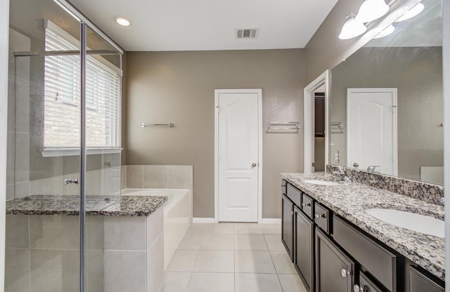 13219 Riata River Ln, Humble, TX 77346 - full bath with double vanity, a bath, a shower stall, tile patterned floors, and baseboards