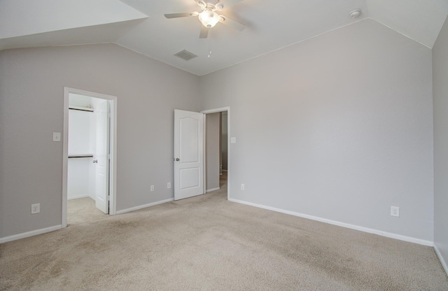 13219 Riata River Ln, Humble, TX 77346 - unfurnished bedroom with vaulted ceiling, light colored carpet, a walk in closet, baseboards, and ceiling fan