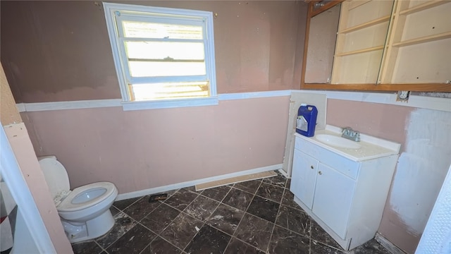 1719 Kansas St, La Marque, TX 77568 - bathroom featuring toilet, vanity, marble look tile flooring, and baseboards