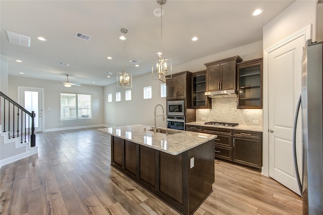 4209 Colony Pines Ln, Houston, TX 77080 - kitchen with a sink, appliances with stainless steel finishes, dark brown cabinetry, decorative backsplash, and a ceiling fan