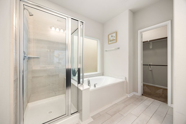 4323 Wyanngate Dr, Spring, TX 77373 - bathroom with a shower stall, a walk in closet, a bath, and baseboards