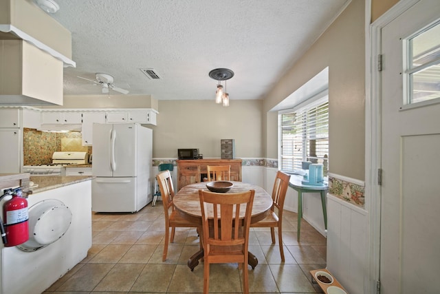 5111 Halbert Dr, Pearland, TX 77581 - dining space featuring wainscoting, ceiling fan, a textured ceiling, and light tile patterned floors