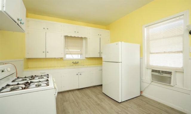 4915 Walker St, Houston, TX 77023 - kitchen with white appliances, light countertops, light wood-type flooring, tasteful backsplash, and white cabinets