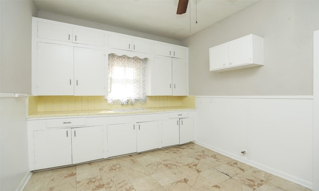 4915 Walker St, Houston, TX 77023 - kitchen with a sink, white cabinetry, ceiling fan, backsplash, and tile counters