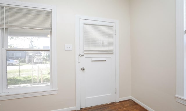 4915 Walker St, Houston, TX 77023 - doorway with baseboards and dark wood finished floors