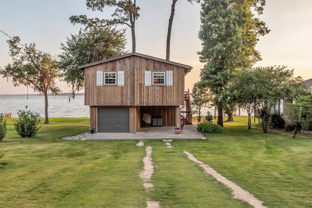 784 W Cattle Dr, Onalaska, TX 77360 - back of house with a water view, a lawn, stairs, and a garage