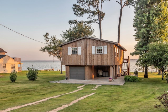 784 W Cattle Dr, Onalaska, TX 77360 - rear view of property with stairway, a water view, a lawn, and a garage