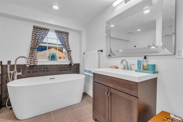 784 W Cattle Dr, Onalaska, TX 77360 - bathroom featuring a freestanding tub, tile walls, vanity, tile patterned floors, and recessed lighting