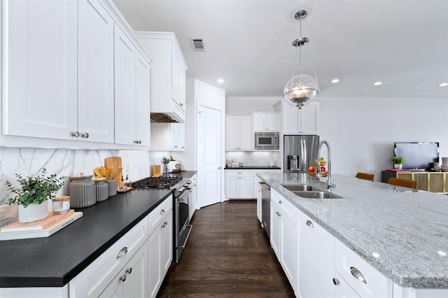 1822 Mcilhenny St Unit B, Houston, TX 77004 - kitchen with stainless steel appliances, a sink, tasteful backsplash, white cabinets, and a spacious island