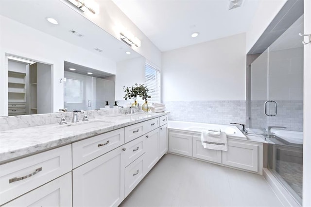 1822 Mcilhenny St Unit B, Houston, TX 77004 - bathroom with double vanity, a garden tub, a stall shower, tile walls, and recessed lighting
