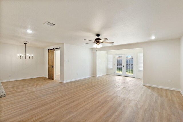 2801 Pickerton Dr, Deer Park, TX 77536 - unfurnished room featuring a barn door, light wood-style floors, ceiling fan, baseboards, and a chandelier