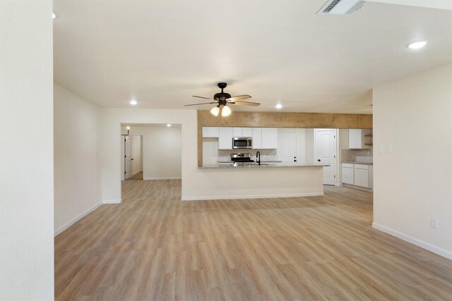 2801 Pickerton Dr, Deer Park, TX 77536 - unfurnished living room with light wood-type flooring, baseboards, ceiling fan, and recessed lighting