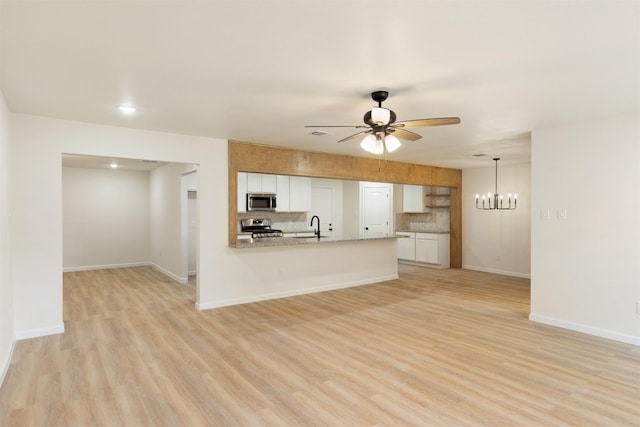 2801 Pickerton Dr, Deer Park, TX 77536 - unfurnished living room with a sink, a ceiling fan, light wood-style flooring, a chandelier, and baseboards