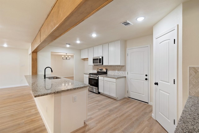2801 Pickerton Dr, Deer Park, TX 77536 - kitchen with appliances with stainless steel finishes, a sink, light stone counters, tasteful backsplash, and a peninsula