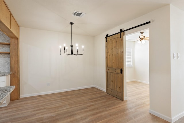 2801 Pickerton Dr, Deer Park, TX 77536 - unfurnished dining area featuring a barn door, light wood-style flooring, baseboards, and a chandelier