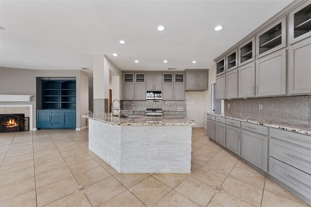 16503 Timberidge Ct, Cypress, TX 77429 - kitchen featuring appliances with stainless steel finishes, gray cabinets, light tile patterned flooring, tasteful backsplash, and recessed lighting