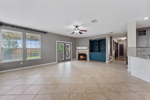 16503 Timberidge Ct, Cypress, TX 77429 - unfurnished living room featuring a ceiling fan, light tile patterned floors, a tile fireplace, and baseboards