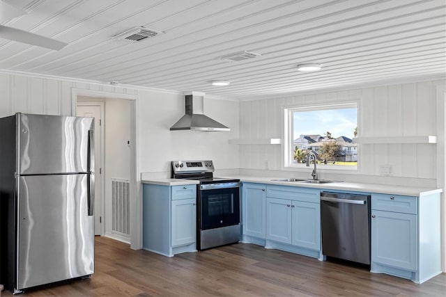 3903 2nd St, Galveston, TX 77554 - kitchen featuring stainless steel appliances, wall chimney exhaust hood, a sink, blue cabinets, and ornamental molding