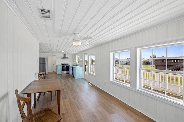3903 2nd St, Galveston, TX 77554 - dining area featuring light wood-style floors, crown molding, and a ceiling fan
