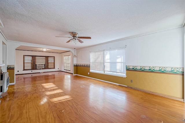 31002 Misty Meadow Dr, Magnolia, TX 77354 - unfurnished living room with a ceiling fan, a textured ceiling, wood finished floors, baseboards, and crown molding