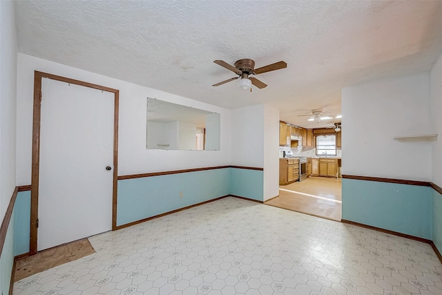 31002 Misty Meadow Dr, Magnolia, TX 77354 - empty room featuring ceiling fan, baseboards, a textured ceiling, and a sink