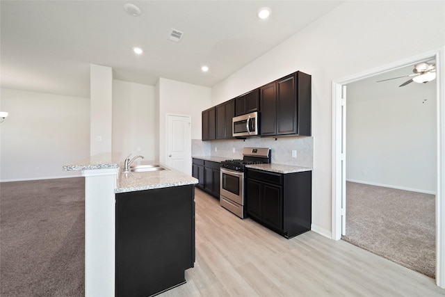 6502 Blimp Base Blvd, Hitchcock, TX 77563 - kitchen with appliances with stainless steel finishes, a sink, backsplash, light stone countertops, and recessed lighting