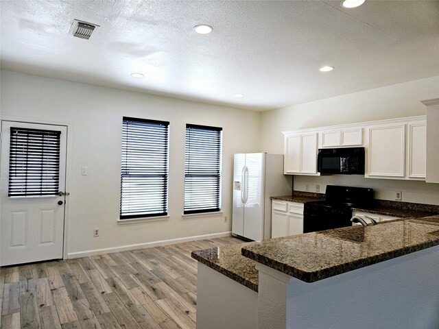 8039 Ellinger Ln, Houston, TX 77040 - kitchen featuring black appliances, light wood finished floors, white cabinetry, dark stone countertops, and recessed lighting