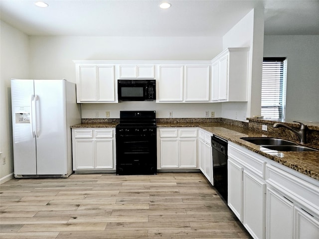 8039 Ellinger Ln, Houston, TX 77040 - kitchen featuring black appliances, a sink, light wood-style flooring, dark stone countertops, and recessed lighting
