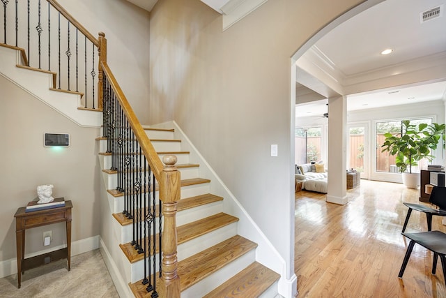 2306 Mcduffie St, Houston, TX 77019 - stairway featuring arched walkways, ornamental molding, wood finished floors, baseboards, and a ceiling fan