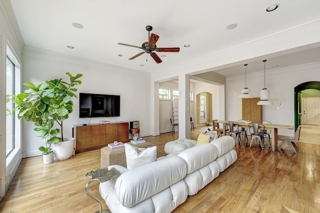 2306 Mcduffie St, Houston, TX 77019 - living area featuring arched walkways, a ceiling fan, ornamental molding, and light wood finished floors