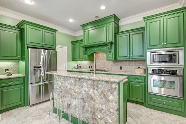 2306 Mcduffie St, Houston, TX 77019 - kitchen with appliances with stainless steel finishes, tasteful backsplash, ornamental molding, a center island with sink, and recessed lighting