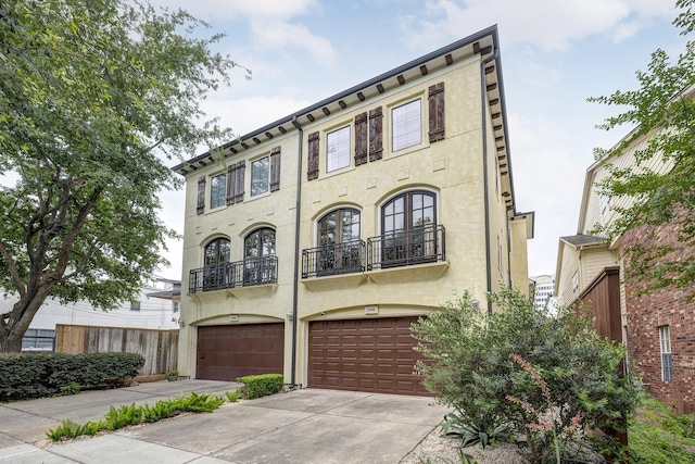 2306 Mcduffie St, Houston, TX 77019 - townhome / multi-family property featuring stucco siding, concrete driveway, an attached garage, and a balcony
