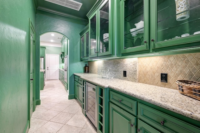 2306 Mcduffie St, Houston, TX 77019 - indoor bar featuring beverage cooler, ornamental molding, backsplash, light tile patterned floors, and arched walkways